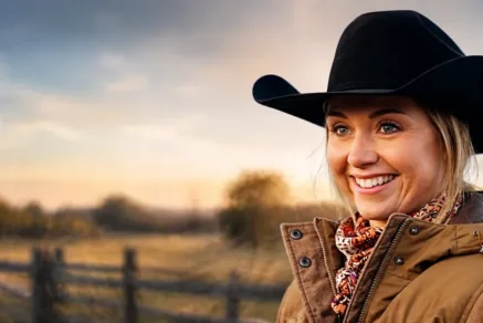 Amber Marshall as Amy Fleming standing on a ranch in Heartland, reflecting real-life connection to her role