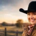Amber Marshall as Amy Fleming standing on a ranch in Heartland, reflecting real-life connection to her role