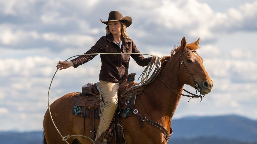 Amber Marshall as Amy Fleming riding a horse on the Heartland ranch