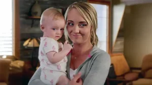 Amber Marshall as Amy Fleming holding her baby at the Heartland ranch