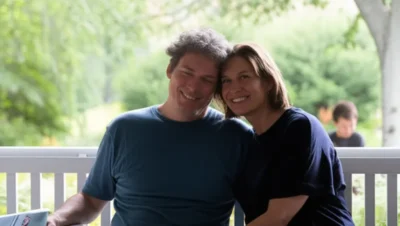 Christopher and Dana Reeve sitting together with their son Will, sharing a peaceful family moment outdoors
