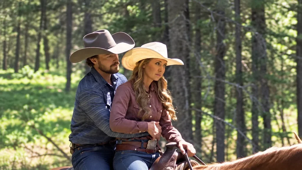 Amy Fleming and Nathan Pryce riding together on horseback in a wooded setting.