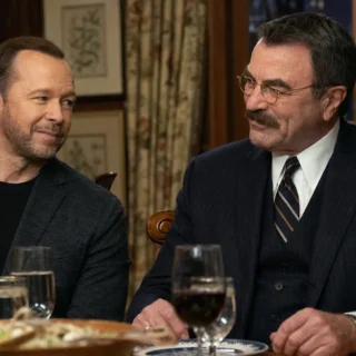 Donnie Wahlberg and Tom Selleck seated together at a family dinner table