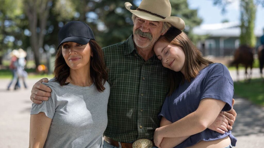 Shaun Johnston as Jack Bartlett hugging Michelle Morgan as Lou and Baye McPherson as Katie outside on the Heartland ranch
