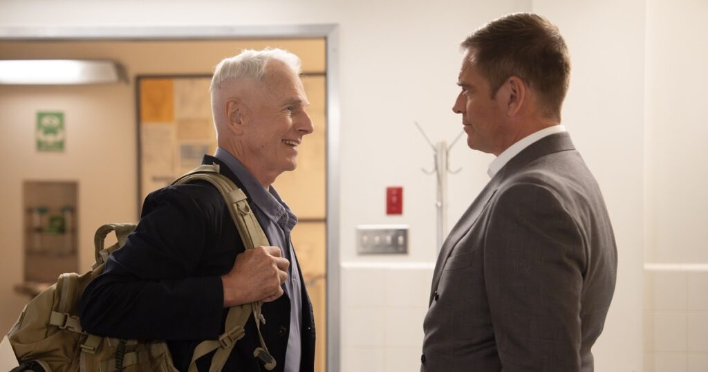 Mark Harmon as Gibbs, carrying a backpack and smiling at Michael Weatherly as NCIS Director Tony DiNozzo at NCIS headquarters